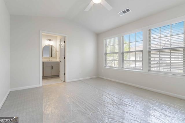 unfurnished bedroom with a sink, visible vents, vaulted ceiling, a ceiling fan, and baseboards