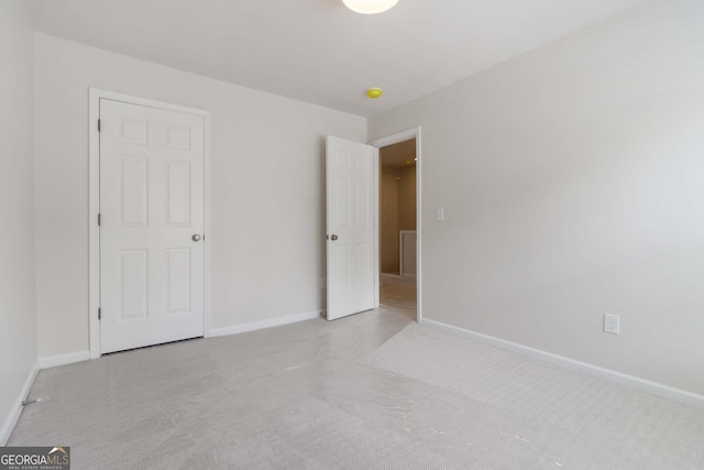 unfurnished bedroom with baseboards and carpet