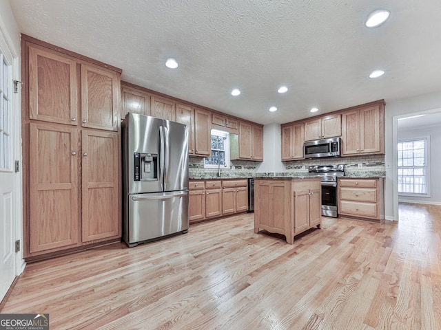 kitchen with backsplash, recessed lighting, appliances with stainless steel finishes, and light wood-style floors
