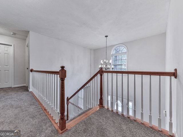 stairway with an inviting chandelier and carpet