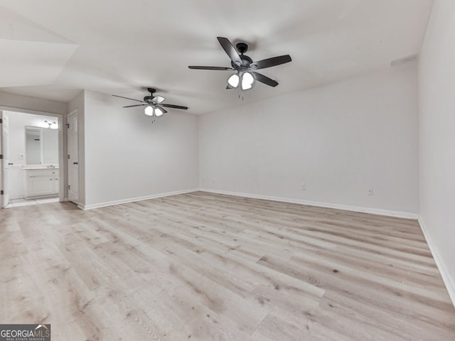unfurnished room featuring ceiling fan, light wood-style flooring, and baseboards