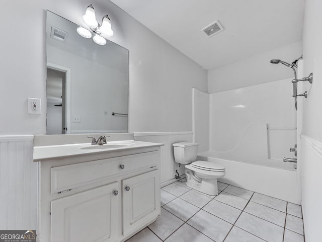 bathroom featuring vanity, tile patterned floors, toilet, visible vents, and wainscoting