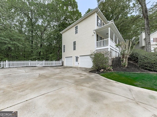 view of home's exterior with fence, driveway, and an attached garage