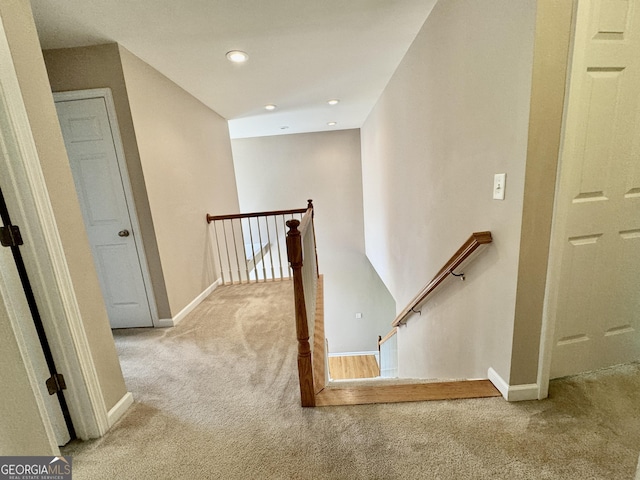 corridor featuring carpet floors, an upstairs landing, and baseboards
