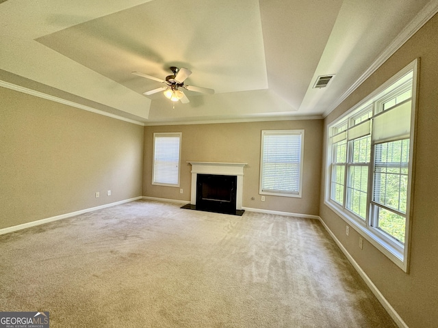 unfurnished living room featuring a tray ceiling, a wealth of natural light, and visible vents