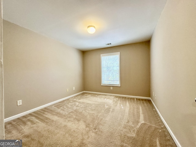 empty room with visible vents, baseboards, and carpet flooring