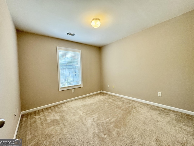 carpeted empty room with visible vents and baseboards