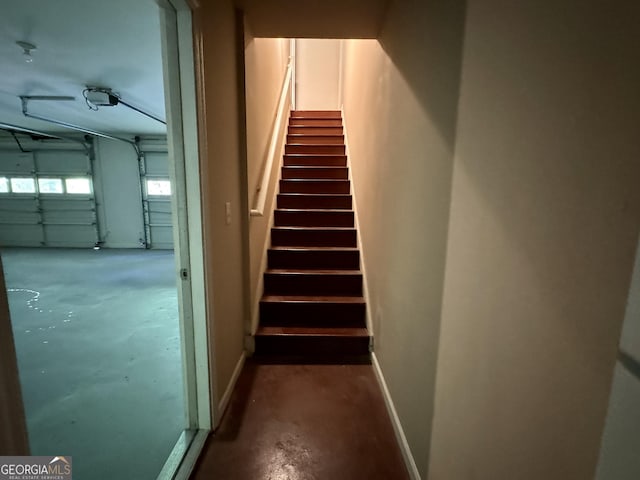 stairway featuring unfinished concrete flooring