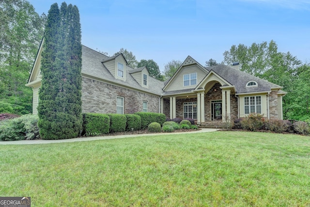 craftsman house with stone siding, a chimney, a front yard, and roof with shingles