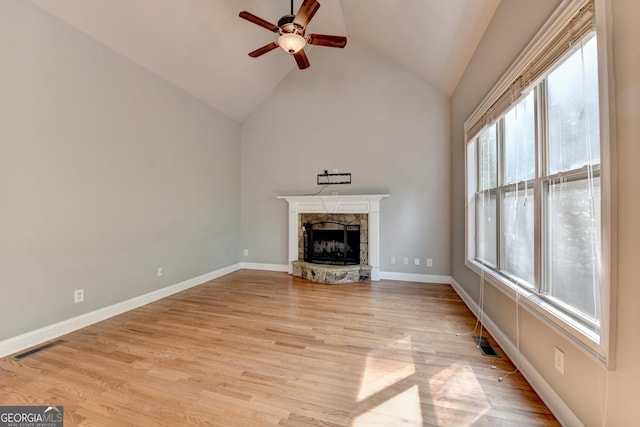 unfurnished living room featuring visible vents, a ceiling fan, light wood-style floors, and a fireplace