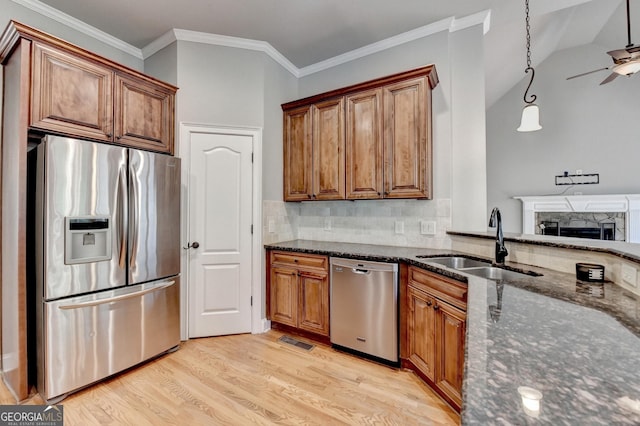 kitchen with a sink, stainless steel appliances, brown cabinets, and visible vents