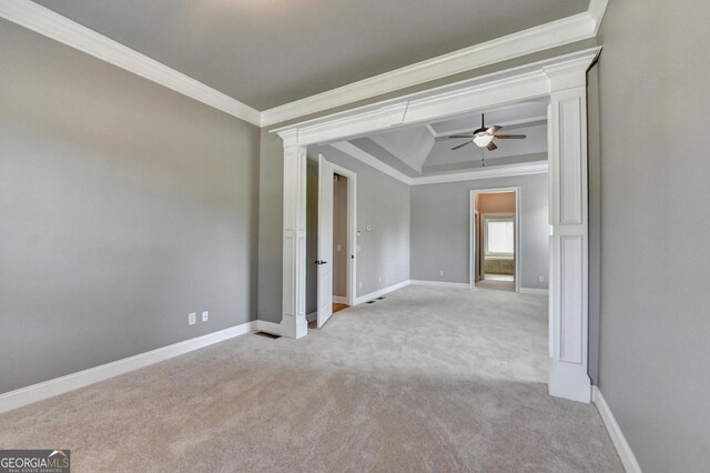 spare room featuring ornamental molding, decorative columns, light carpet, baseboards, and a ceiling fan