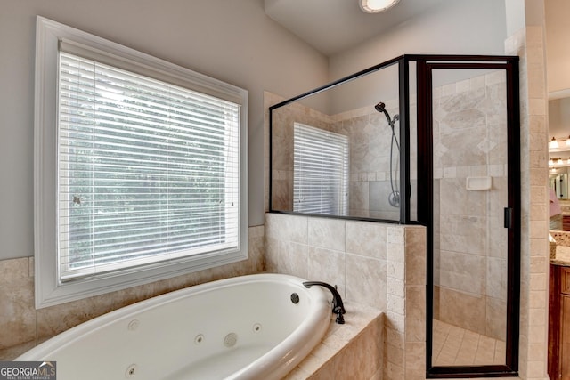 full bathroom featuring a jetted tub, vanity, and a shower stall