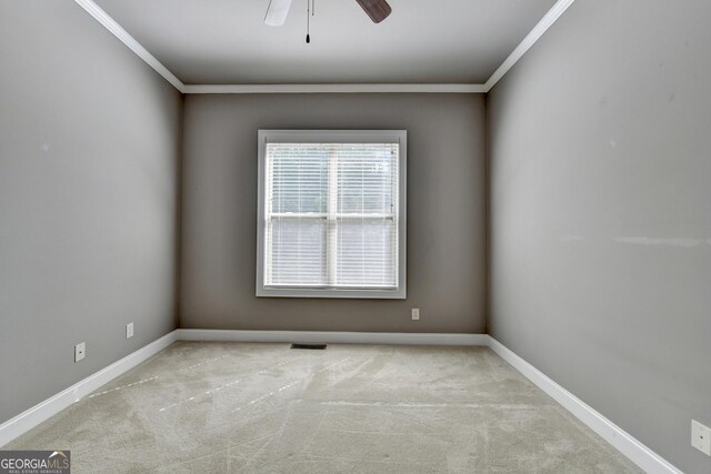 carpeted empty room featuring ceiling fan, visible vents, ornamental molding, and baseboards