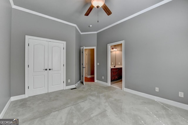 unfurnished bedroom featuring ceiling fan, baseboards, a closet, ornamental molding, and carpet flooring