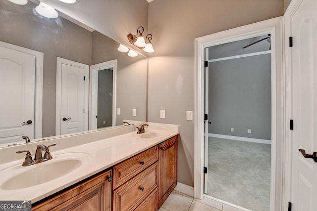 full bathroom featuring double vanity, baseboards, a sink, and tile patterned floors