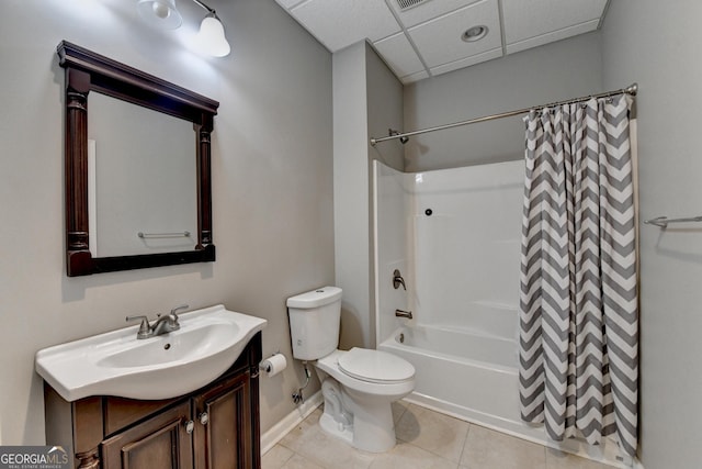 full bathroom with vanity, toilet, baseboards, a drop ceiling, and tile patterned floors