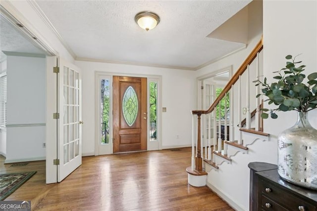 22 Oakwood Hills Dr, Suwanee, GA 30024 - foyer featuring a textured ceiling, baseboards, wood finished floors, ornamental molding, and stairway