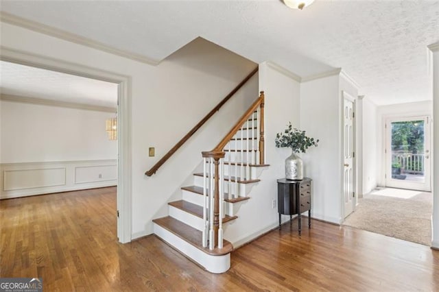 22 Oakwood Hills Dr, Suwanee, GA 30024 - staircase featuring a textured ceiling, ornamental molding, and wood finished floors