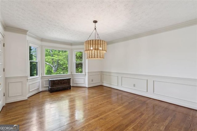 22 Oakwood Hills Dr, Suwanee, GA 30024 - unfurnished dining area with wood finished floors, a wainscoted wall, a textured ceiling, and a chandelier