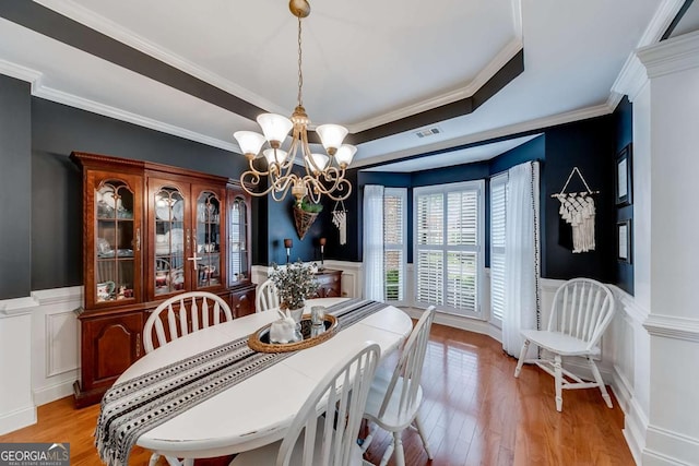 1738 Honey Tree Pl, Hoschton, GA 30548 - dining area featuring a decorative wall, a wainscoted wall, a chandelier, light wood finished floors, and a tray ceiling