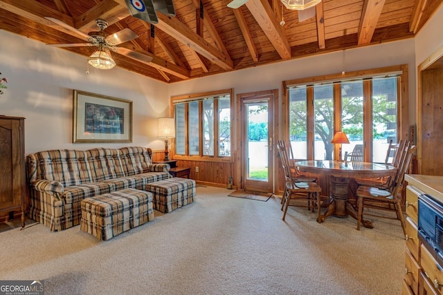 living room with carpet flooring, wooden walls, ceiling fan, lofted ceiling with beams, and wood ceiling