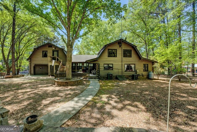 colonial inspired home with an outbuilding, log exterior, and a gambrel roof