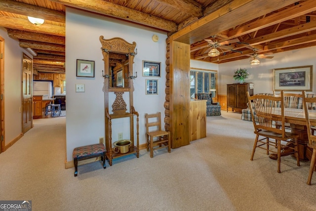 carpeted dining space with wood ceiling, ceiling fan, and beam ceiling