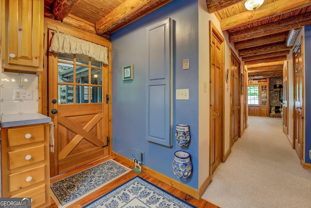 interior space with wooden ceiling, baseboards, beam ceiling, and visible vents