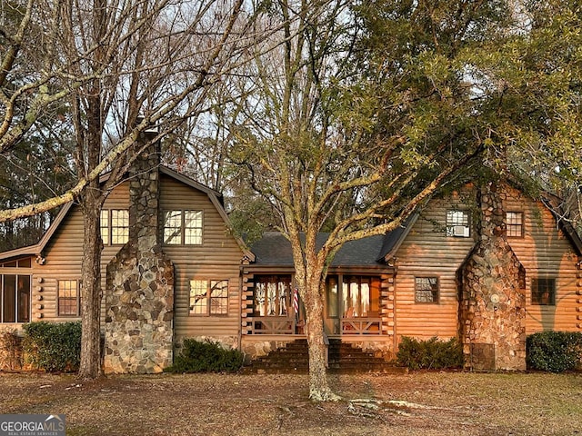 rear view of house featuring a gambrel roof and a detached garage