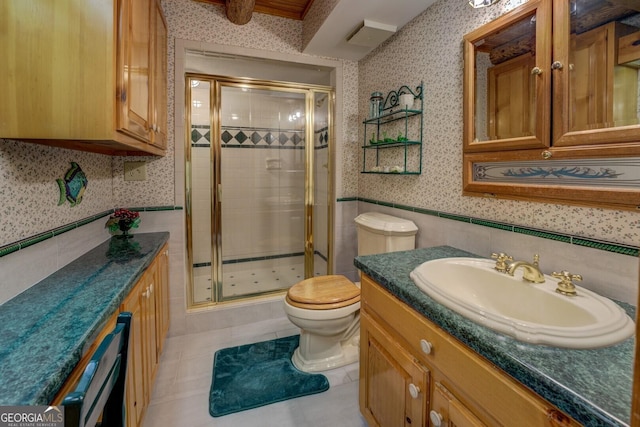 bathroom with vanity, toilet, a wainscoted wall, wallpapered walls, and a shower stall