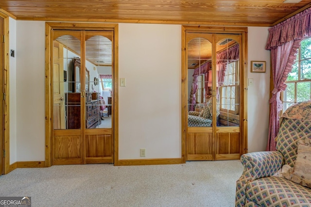sitting room featuring wood ceiling, baseboards, and carpet