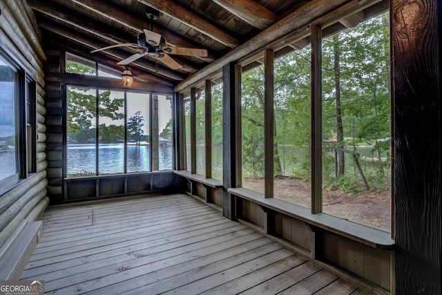 unfurnished sunroom featuring a water view, ceiling fan, and beam ceiling