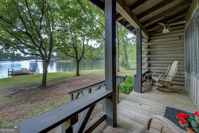 wooden terrace with a lawn, a ceiling fan, and a water view