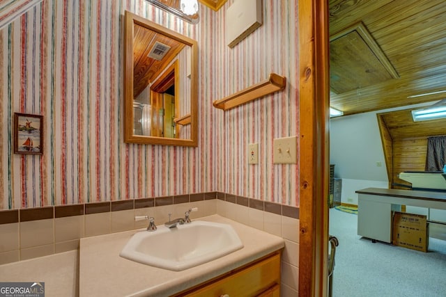 bathroom featuring vanity, a wainscoted wall, wallpapered walls, visible vents, and wood ceiling