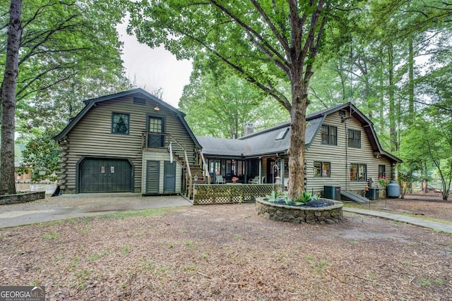 dutch colonial featuring a garage, covered porch, driveway, and a gambrel roof