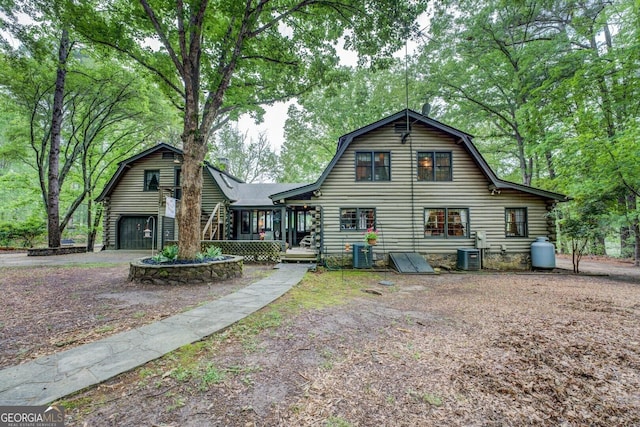 view of front of home featuring central AC, log siding, and a gambrel roof