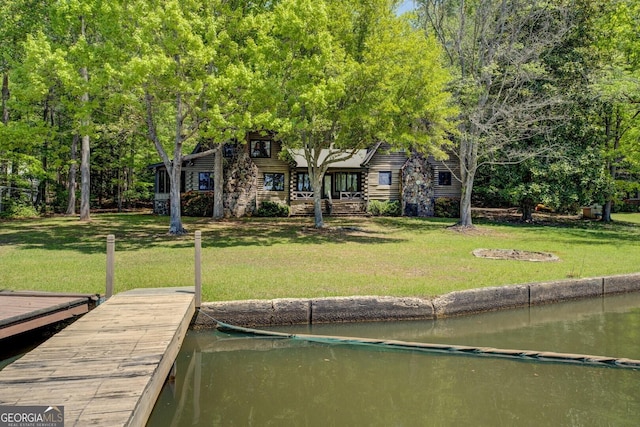 dock area with a water view and a yard