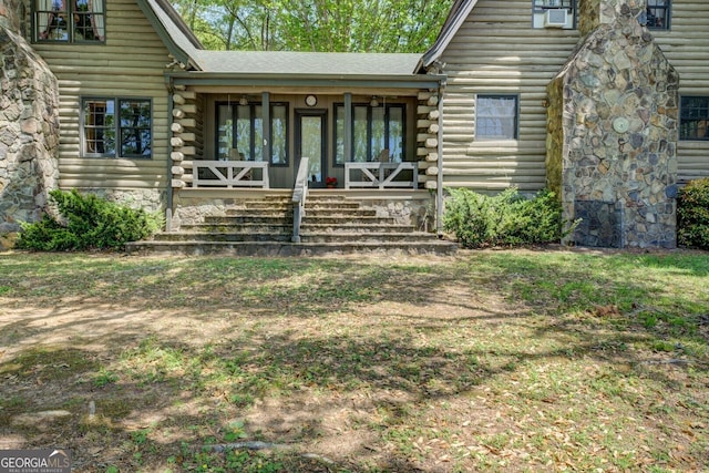 view of exterior entry featuring a porch and log exterior