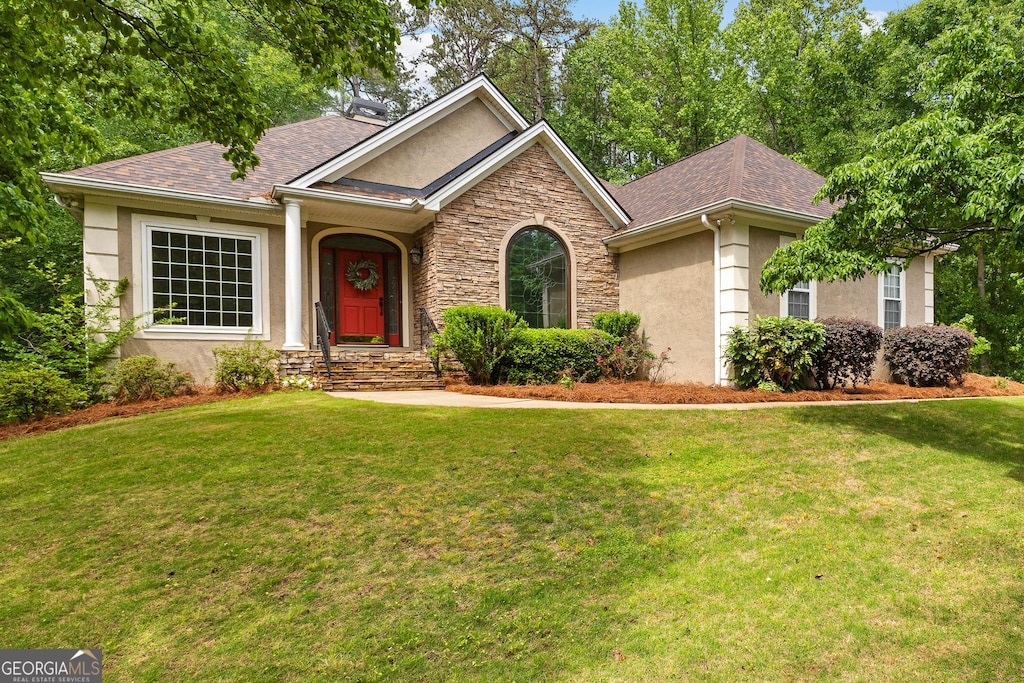 40 High St, Sharpsburg, GA 30277 - view of front facade with a front lawn, stone siding, stucco siding, and a shingled roof