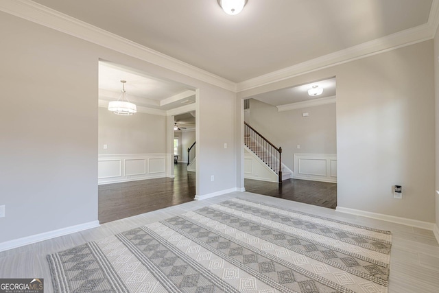 207 Cherokee Reserve Cir, Canton, GA 30115 - empty room with stairway, crown molding, a ceiling fan, a decorative wall, and wainscoting