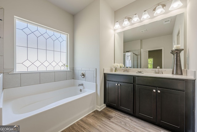 207 Cherokee Reserve Cir, Canton, GA 30115 - bathroom featuring a sink, a bath, double vanity, visible vents, and wood finished floors