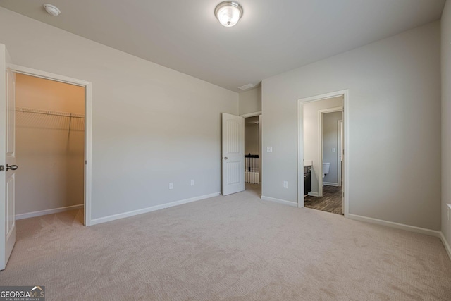 207 Cherokee Reserve Cir, Canton, GA 30115 - unfurnished bedroom with a walk in closet, baseboards, ensuite bath, and carpet