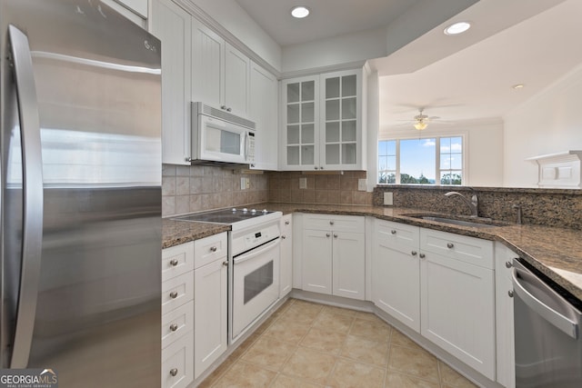 kitchen featuring backsplash, a ceiling fan, appliances with stainless steel finishes, and a sink