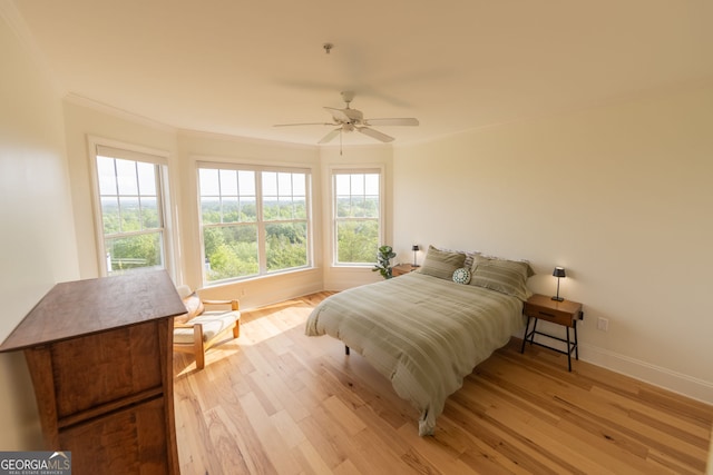 bedroom featuring light wood-type flooring, ornamental molding, baseboards, and ceiling fan
