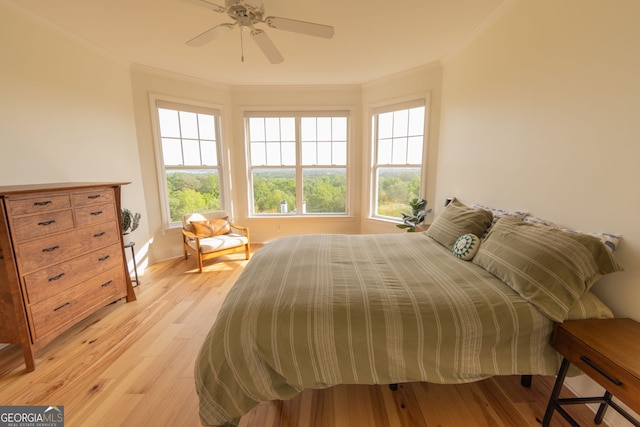 bedroom with ornamental molding, light wood-style floors, ceiling fan, and baseboards