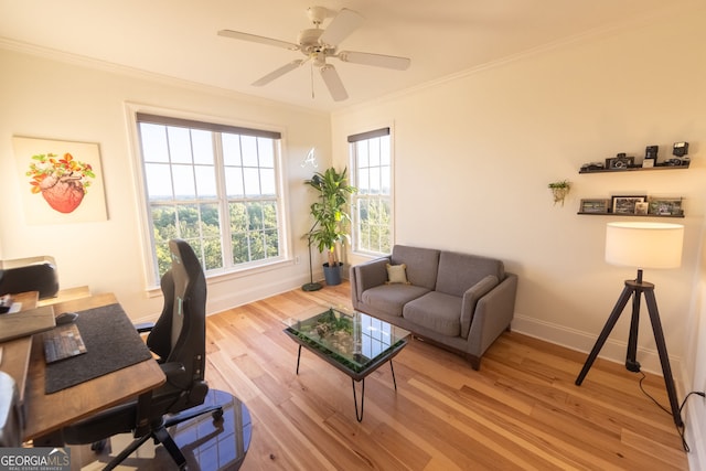 home office featuring baseboards, ornamental molding, light wood-style flooring, and a ceiling fan