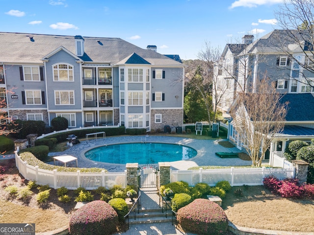 community pool with a gate and a fenced front yard
