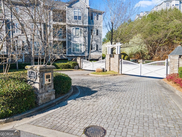 view of road with a gate, curbs, and a gated entry