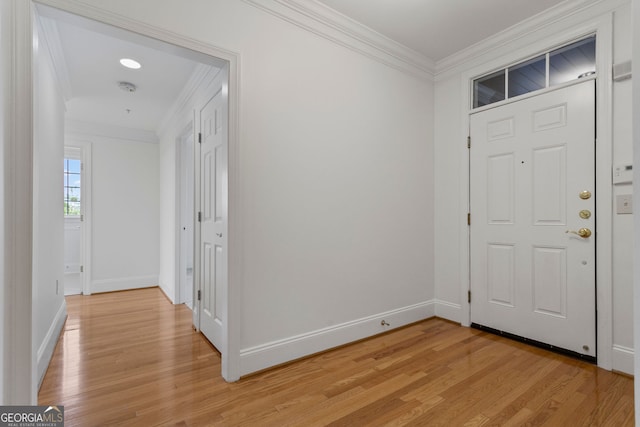 entryway featuring light wood-style flooring, crown molding, and baseboards